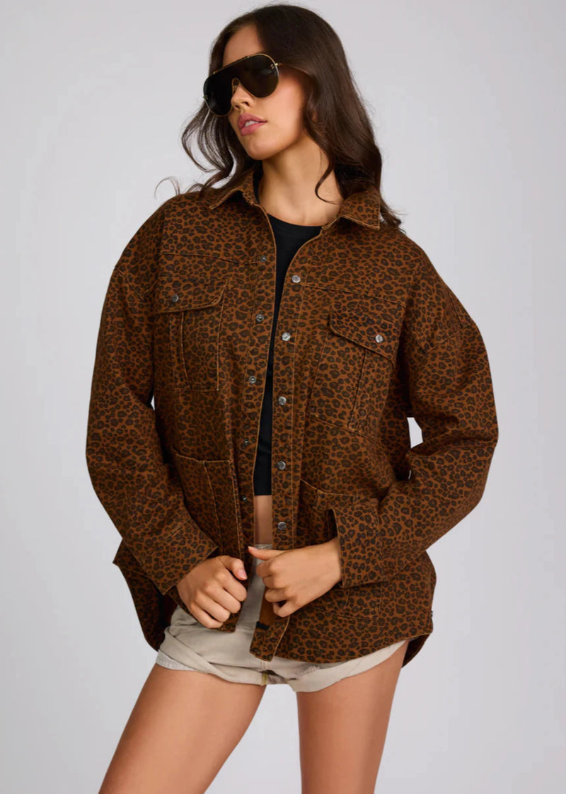 Woman wearing a brown leopard print jacket on a gray background